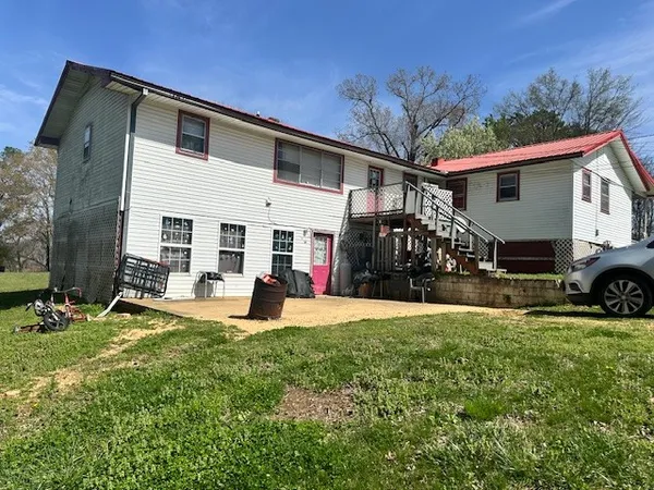 a view of a house with backyard and sitting area