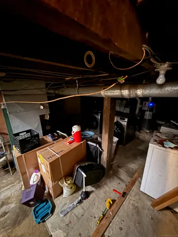 a room with water heater and wooden cabinets