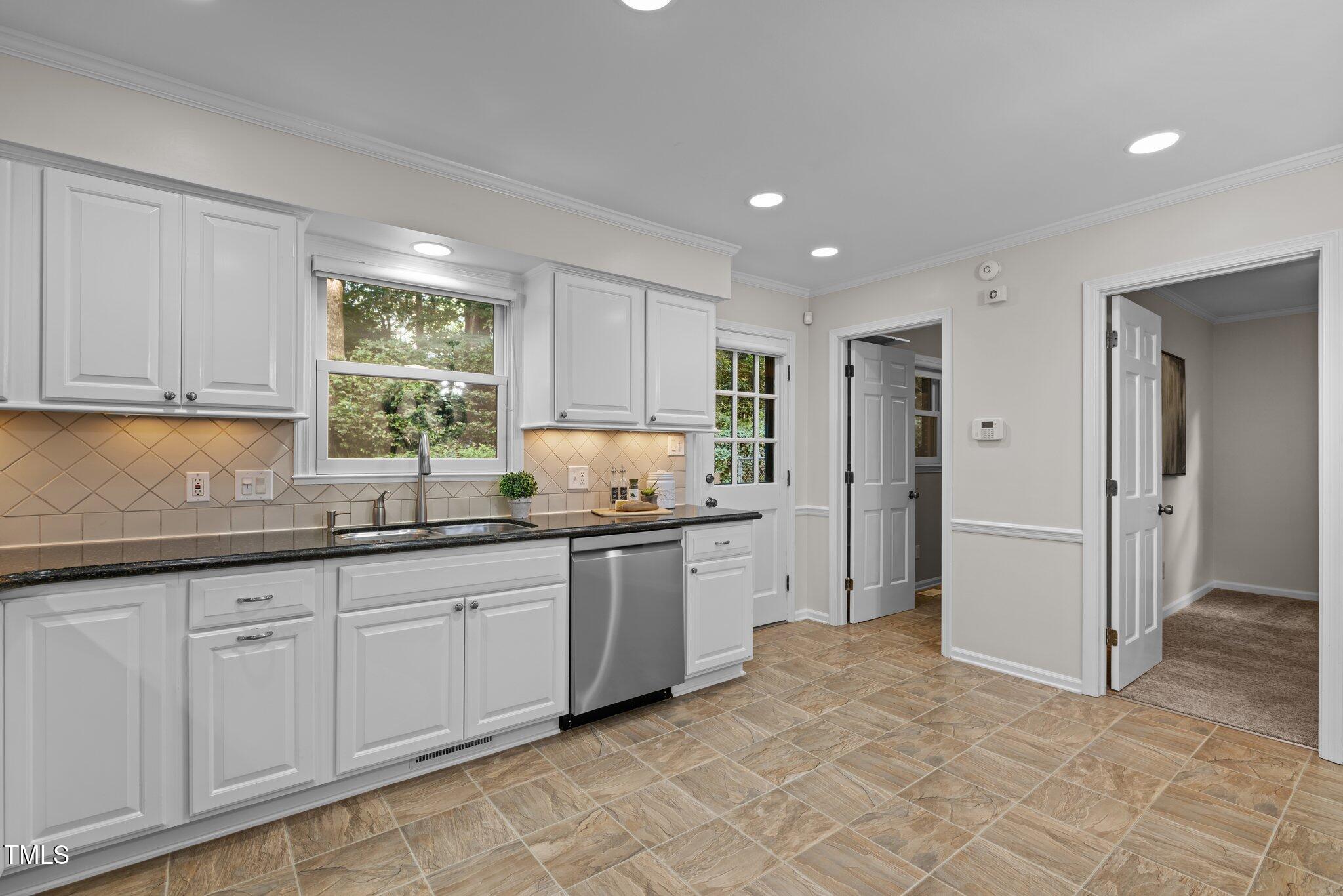 6925 Valley Lake Drive Raleigh, NC 27612 - Photo 12 of 50 a kitchen with granite countertop a sink and white cabinets