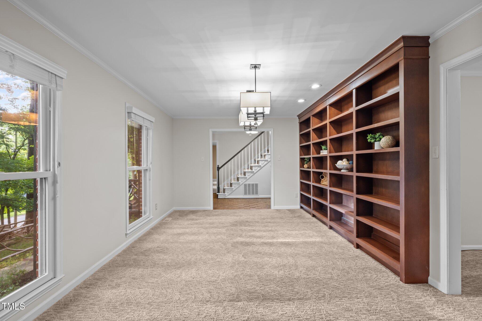 6925 Valley Lake Drive Raleigh, NC 27612 - Photo 17 of 50 a view of an empty room with a staircase and a window