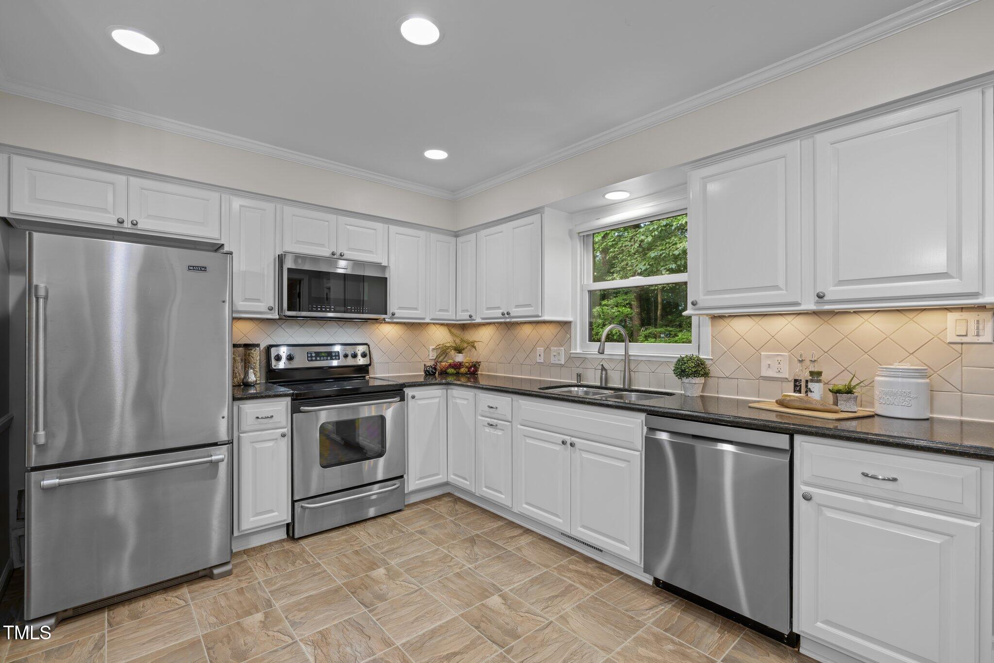 6925 Valley Lake Drive Raleigh, NC 27612 - Photo 10 of 50 a kitchen with a sink stainless steel appliances and window