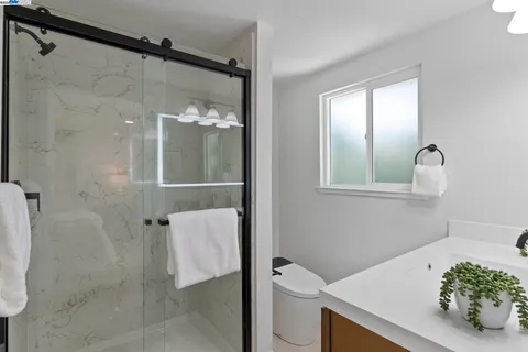 a bathroom with a sink vanity mirror and shower
