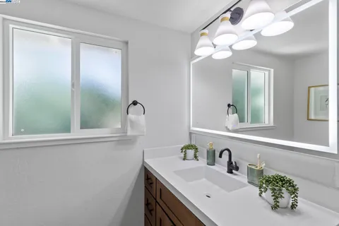 a bathroom with a sink vanity and a mirror