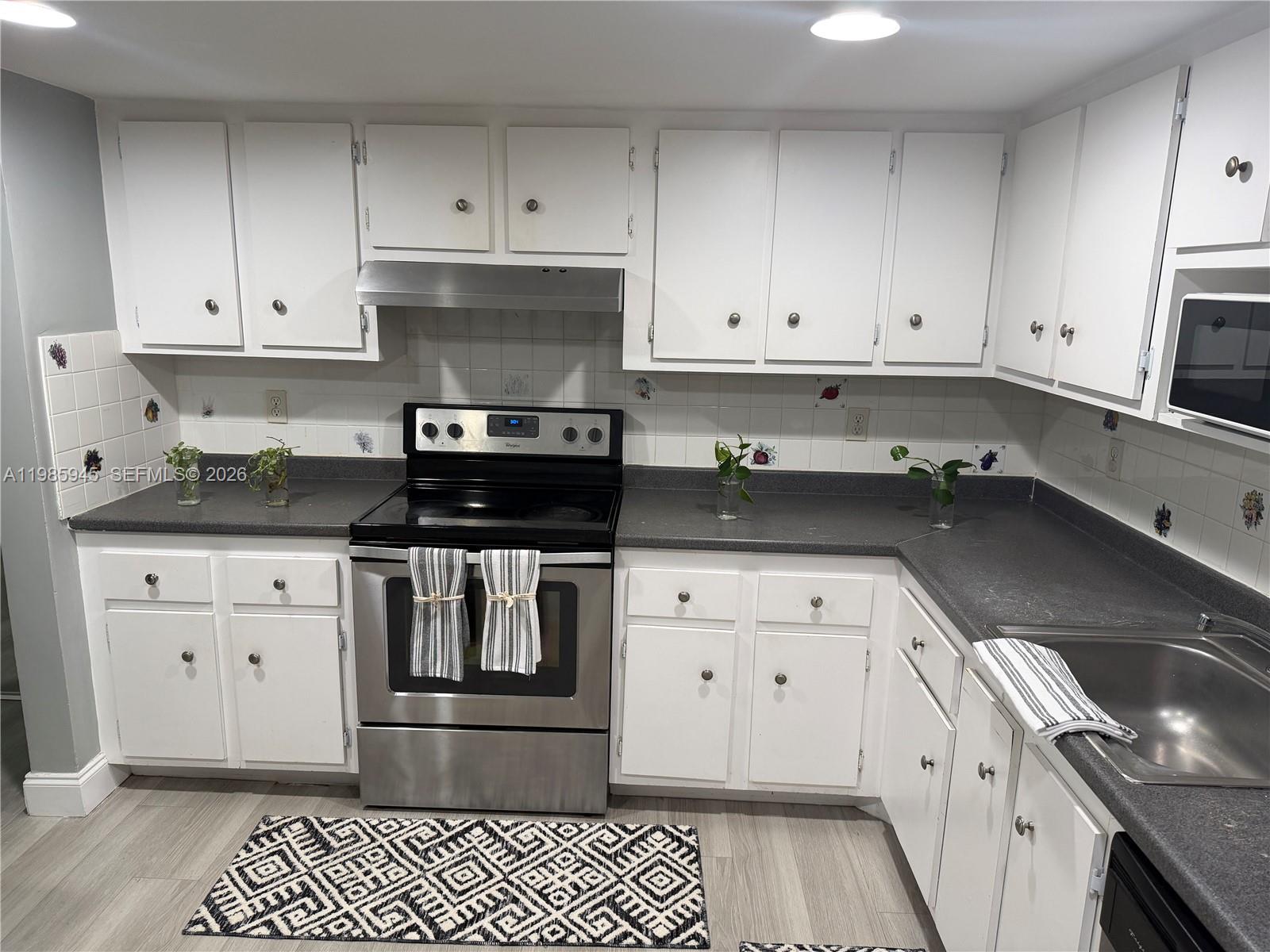 3962 Inverrary Drive, Unit A3 Lauderhill, FL 33319 - Photo 12 of 42 a kitchen with granite countertop white cabinets and stainless steel appliances