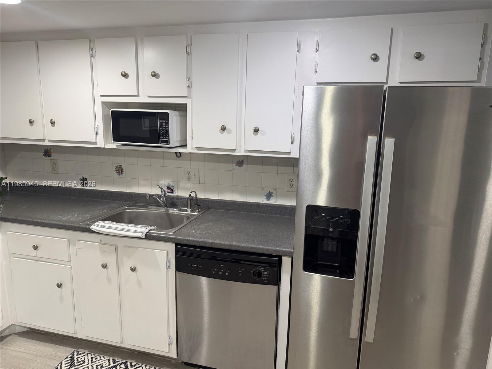 3962 Inverrary Drive, Unit A3 Lauderhill, FL 33319 - Photo 13 of 42 a kitchen with stainless steel appliances a refrigerator sink and cabinets