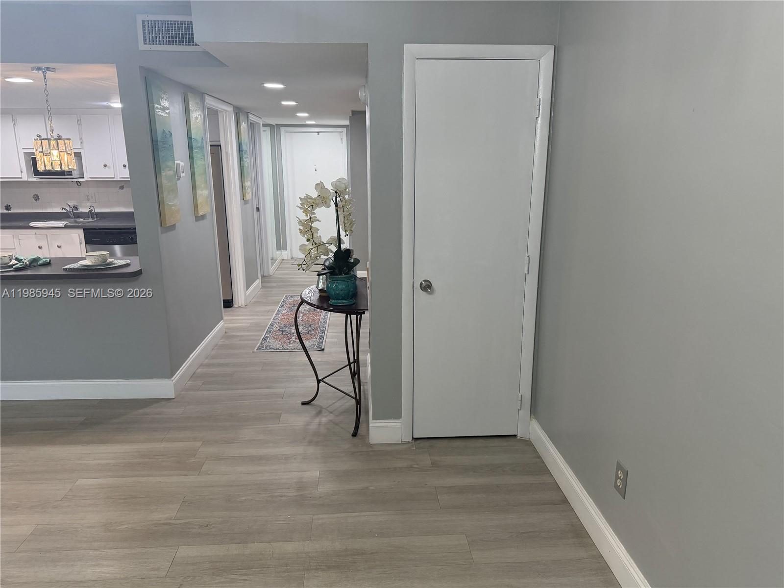 3962 Inverrary Drive, Unit A3 Lauderhill, FL 33319 - Photo 19 of 42 a view of a hallway with wooden floor and a living room
