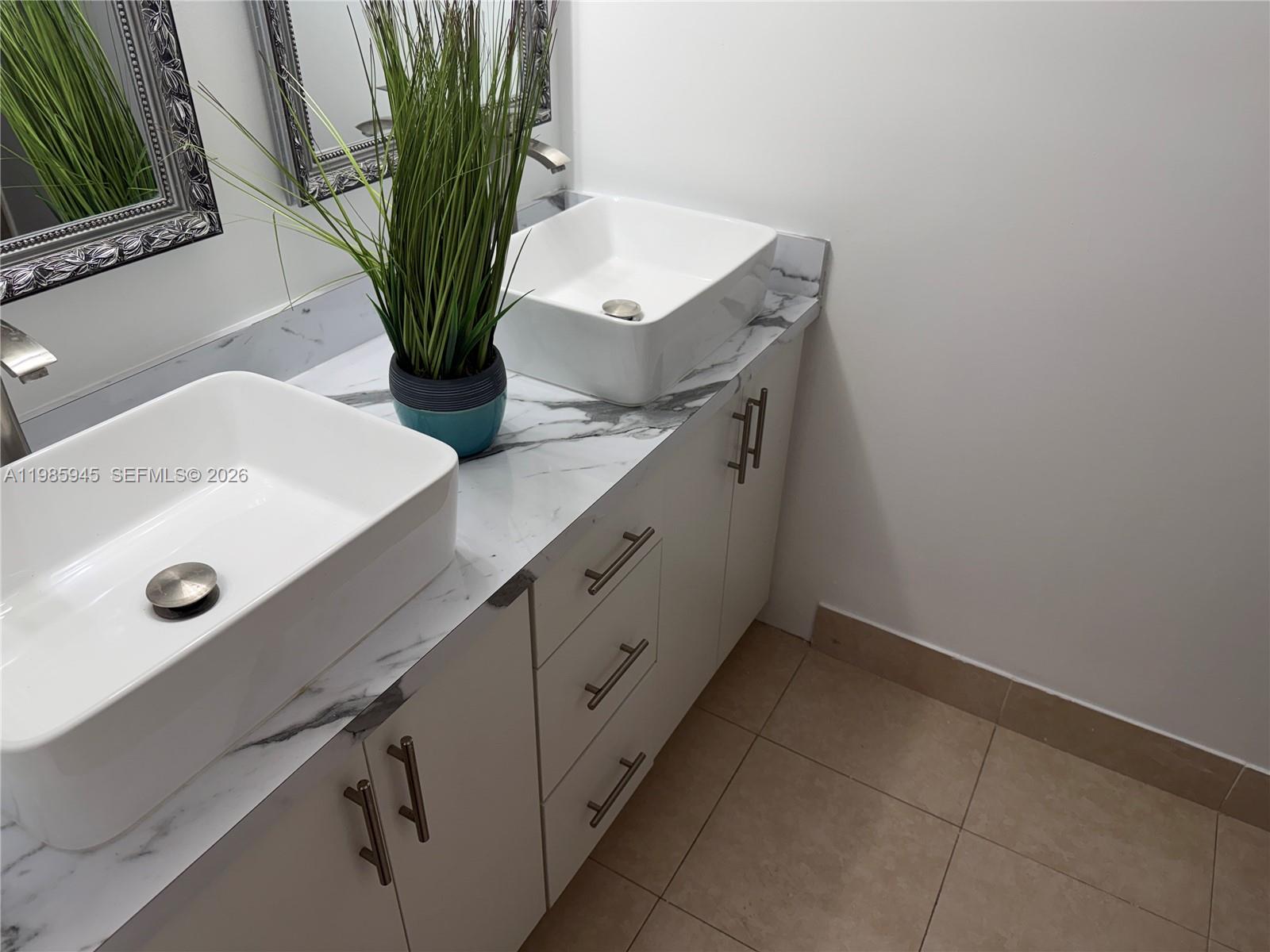 3962 Inverrary Drive, Unit A3 Lauderhill, FL 33319 - Photo 33 of 42 a bathroom with a sink a mirror and a potted plant