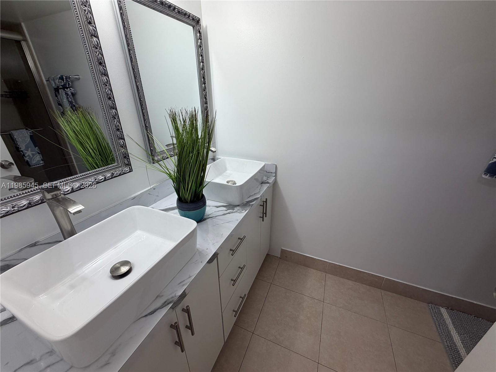3962 Inverrary Drive, Unit A3 Lauderhill, FL 33319 - Photo 34 of 42 a bathroom with a double vanity sink and a mirror