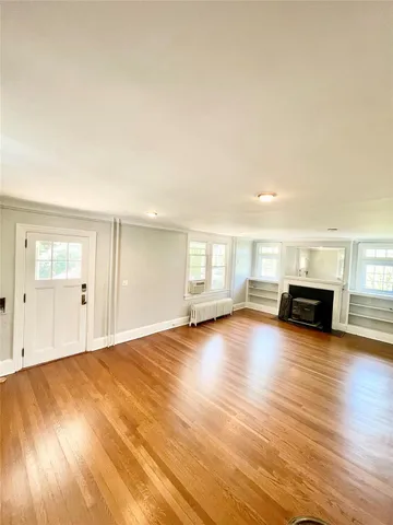 a view of empty room with wooden floor and windows