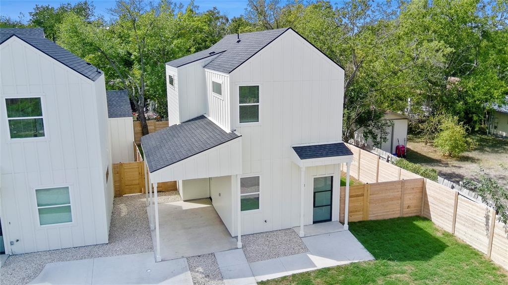 View of front facade featuring a shingled roof, board and batten siding, and a fenced backyard
