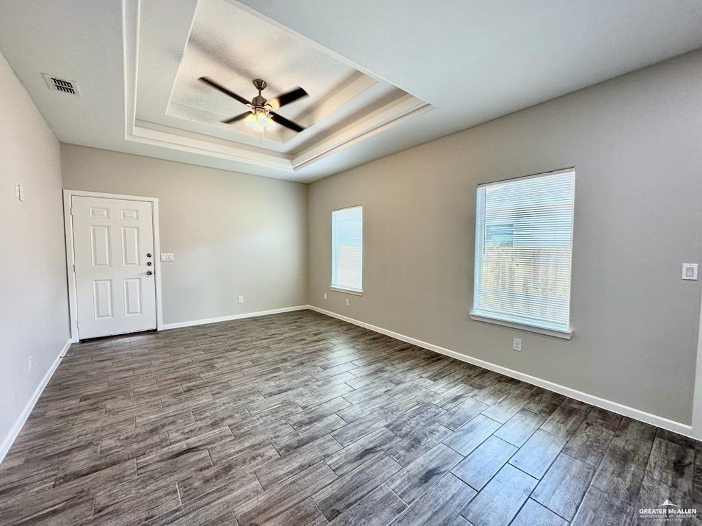 1002 Starr Street Mercedes, TX 78570 - Photo 15 of 17 an empty room with wooden floor ceiling fan and windows