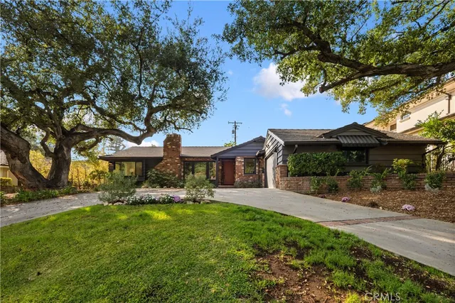 a front view of a house with a yard and trees