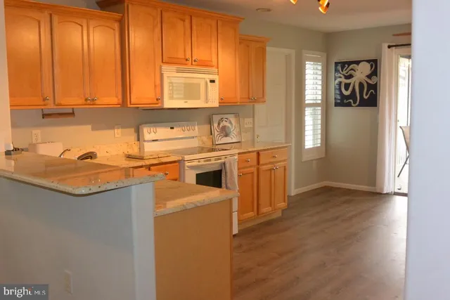 a kitchen with a refrigerator a sink dishwasher with a dining table and chairs