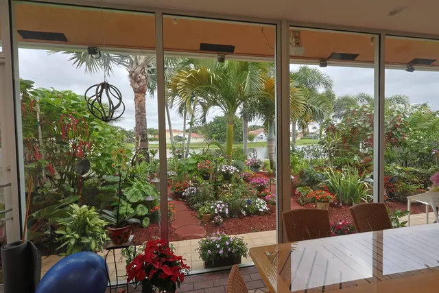 a living room with patio furniture and a floor to ceiling window