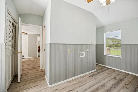 a view of a hallway with wooden floor and closet area