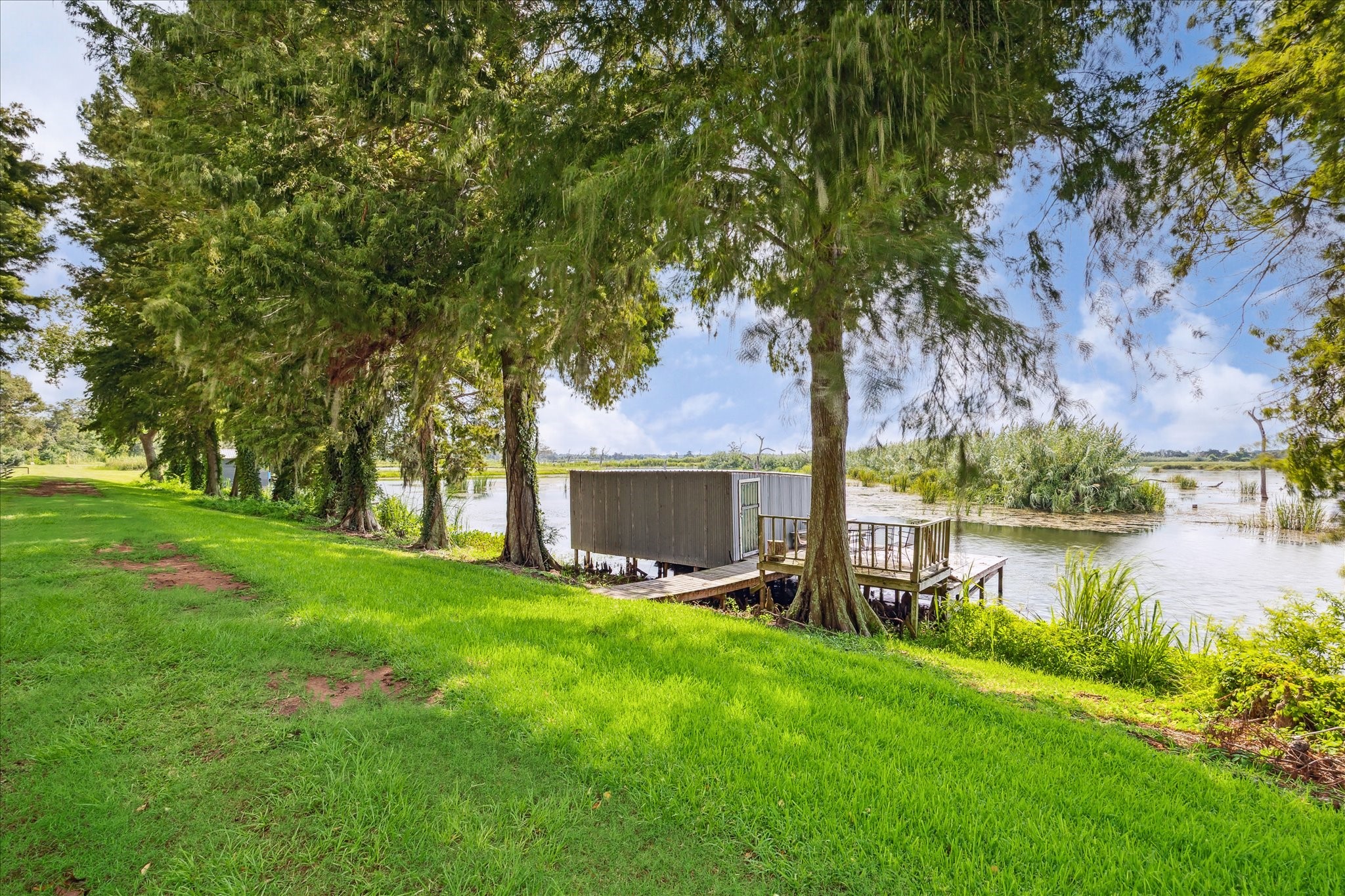29331 County Road 25 Damon, TX 77430 - Photo 21 of 26 a view of a lake with a yard and large trees