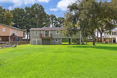 a front view of a house with a garden and trees