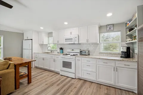 a kitchen with white cabinets sink and stainless steel appliances