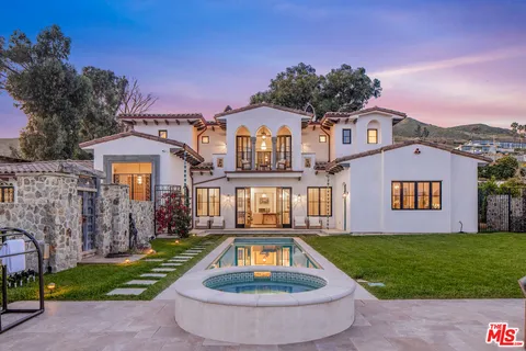 a front view of a house with a yard fire pit and outdoor seating