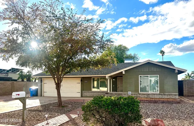 a front view of house with yard and trees around
