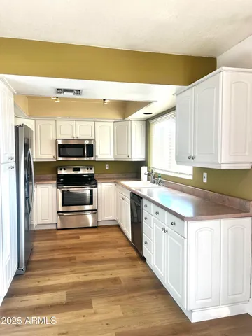 a kitchen with stainless steel appliances a stove a sink and a refrigerator