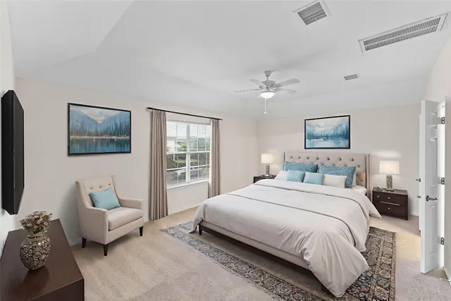 a spacious bedroom with a bed a couch and a flat screen tv