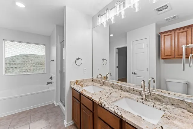 a bathroom with a granite countertop sink mirror and a bath tub