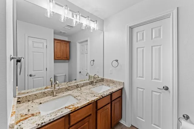 a bathroom with a granite countertop sink and a mirror