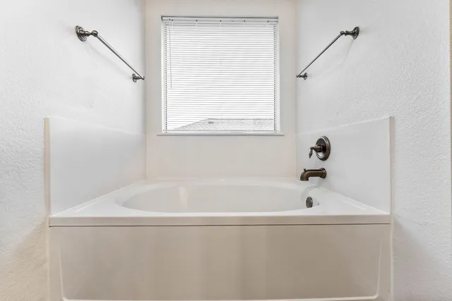 a white bath tub sitting next to a window