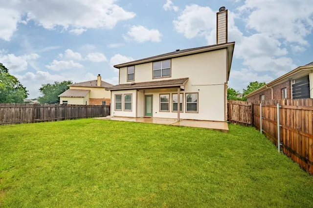 a view of a backyard with plants and wooden fence