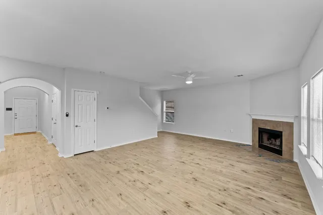 a view of empty room with wooden floor and fireplace