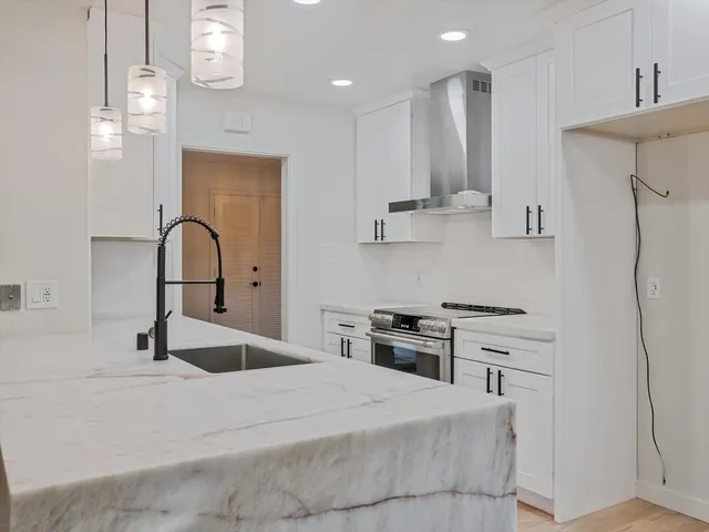 a kitchen with stainless steel appliances granite countertop a sink stove and refrigerator
