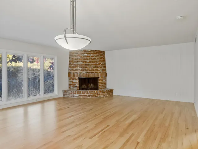 a view of an empty room with glass door and a window