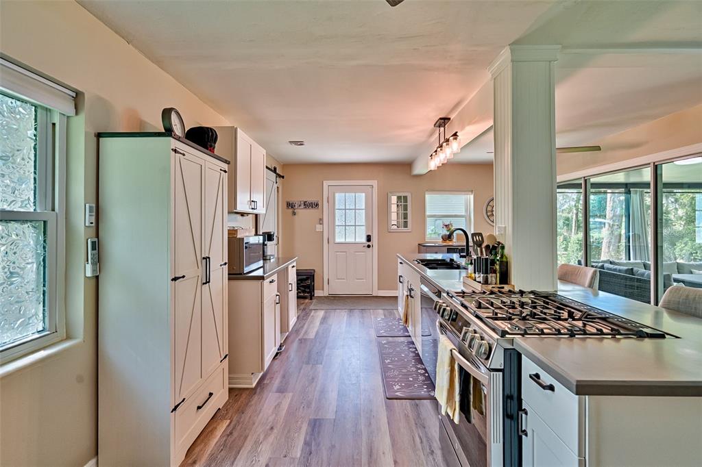 113 Stock Avenue Interlachen, FL 32148 - Photo 12 of 62 a kitchen with stainless steel appliances a refrigerator a stove a sink dishwasher and wooden cabinets with wooden floor