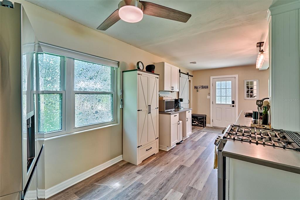 113 Stock Avenue Interlachen, FL 32148 - Photo 14 of 62 a kitchen with stainless steel appliances granite countertop a refrigerator a stove a sink dishwasher and wooden cabinets with wooden floor