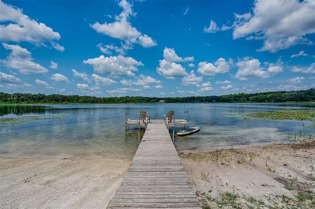 an aerial view of a house with a yard and lake view