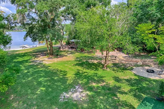 an aerial view of residential house with outdoor space and trees all around