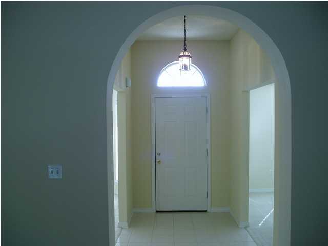 6894 Fernandina Road Navarre, FL 32566 - Photo 3 of 17 an empty room with windows and chandelier