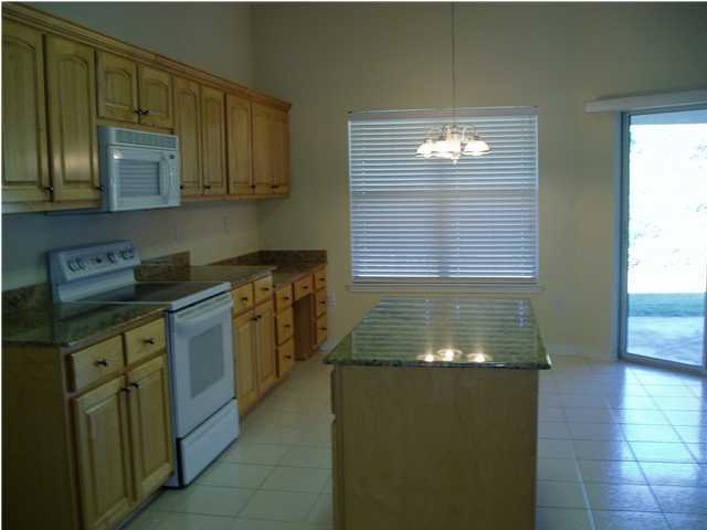 6894 Fernandina Road Navarre, FL 32566 - Photo 7 of 17 a kitchen with stainless steel appliances granite countertop a stove a sink and a microwave