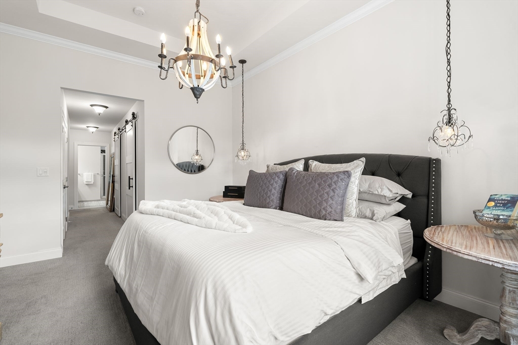 2 Hummingbird Way, Unit 1 Methuen, MA 01844 - Photo 17 of 42 a bedroom with bed and a chandelier