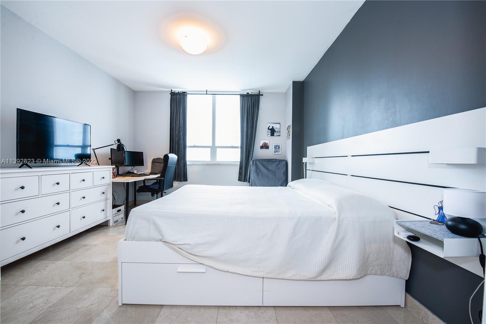 Brickell Miami, FL 33131 - Photo 12 of 50 a bedroom with a bed and a flat tv screen on the dresser