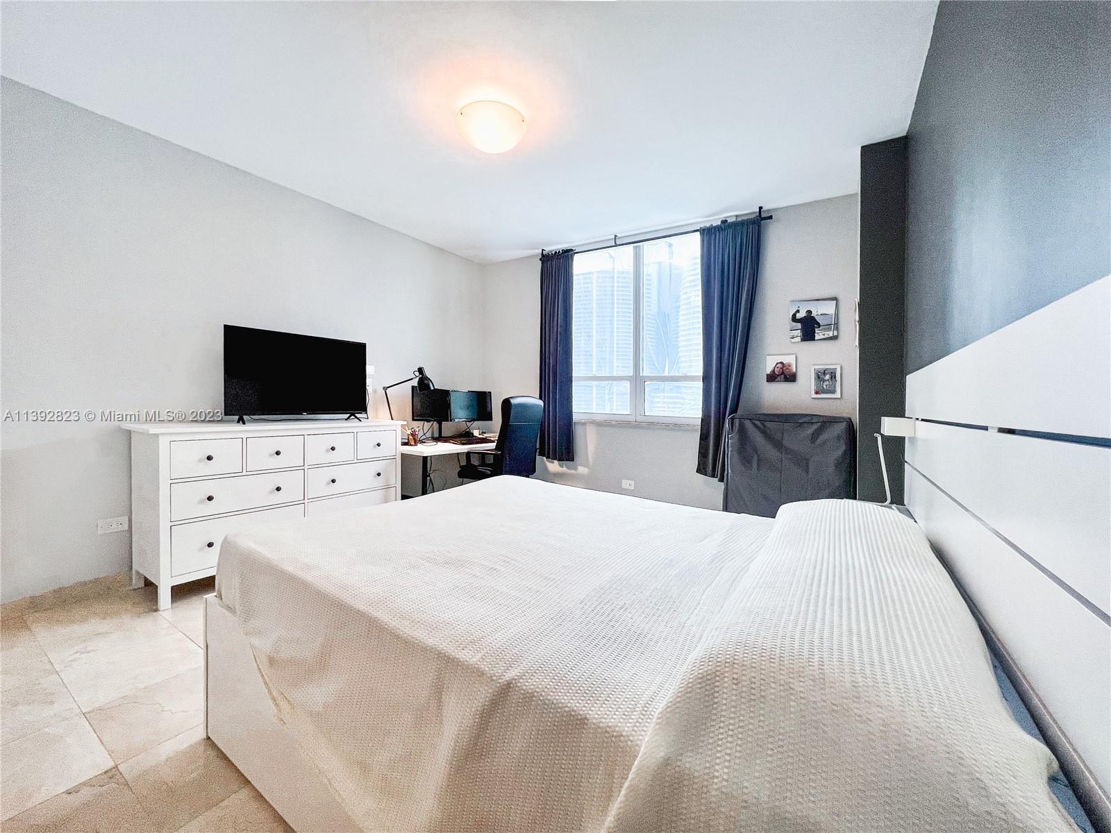 Brickell Miami, FL 33131 - Photo 14 of 50 a bedroom with a bed and a flat screen tv