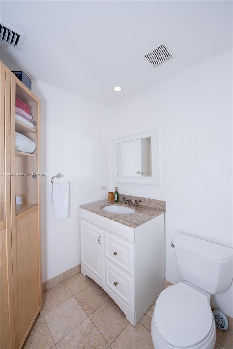 Brickell Miami, FL 33131 - Photo 22 of 50 a bathroom with a granite countertop toilet sink and mirror