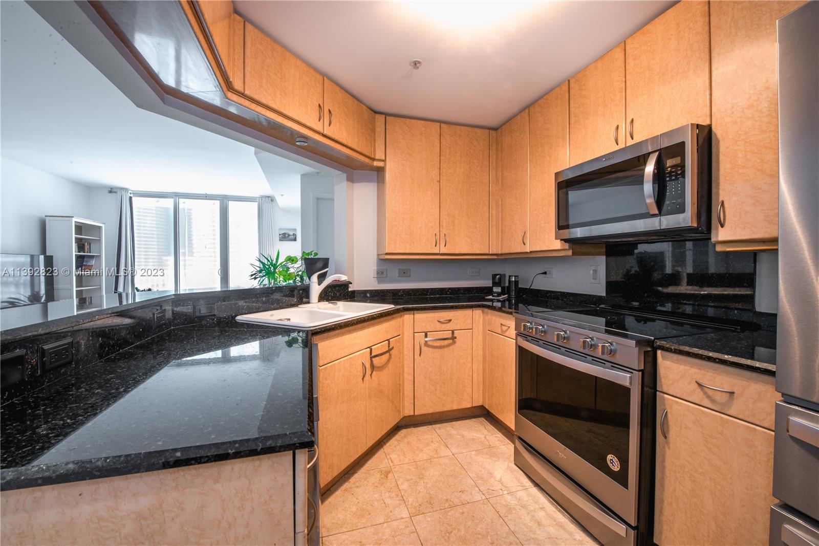 Brickell Miami, FL 33131 - Photo 8 of 50 a kitchen with stainless steel appliances granite countertop a stove a sink and a microwave