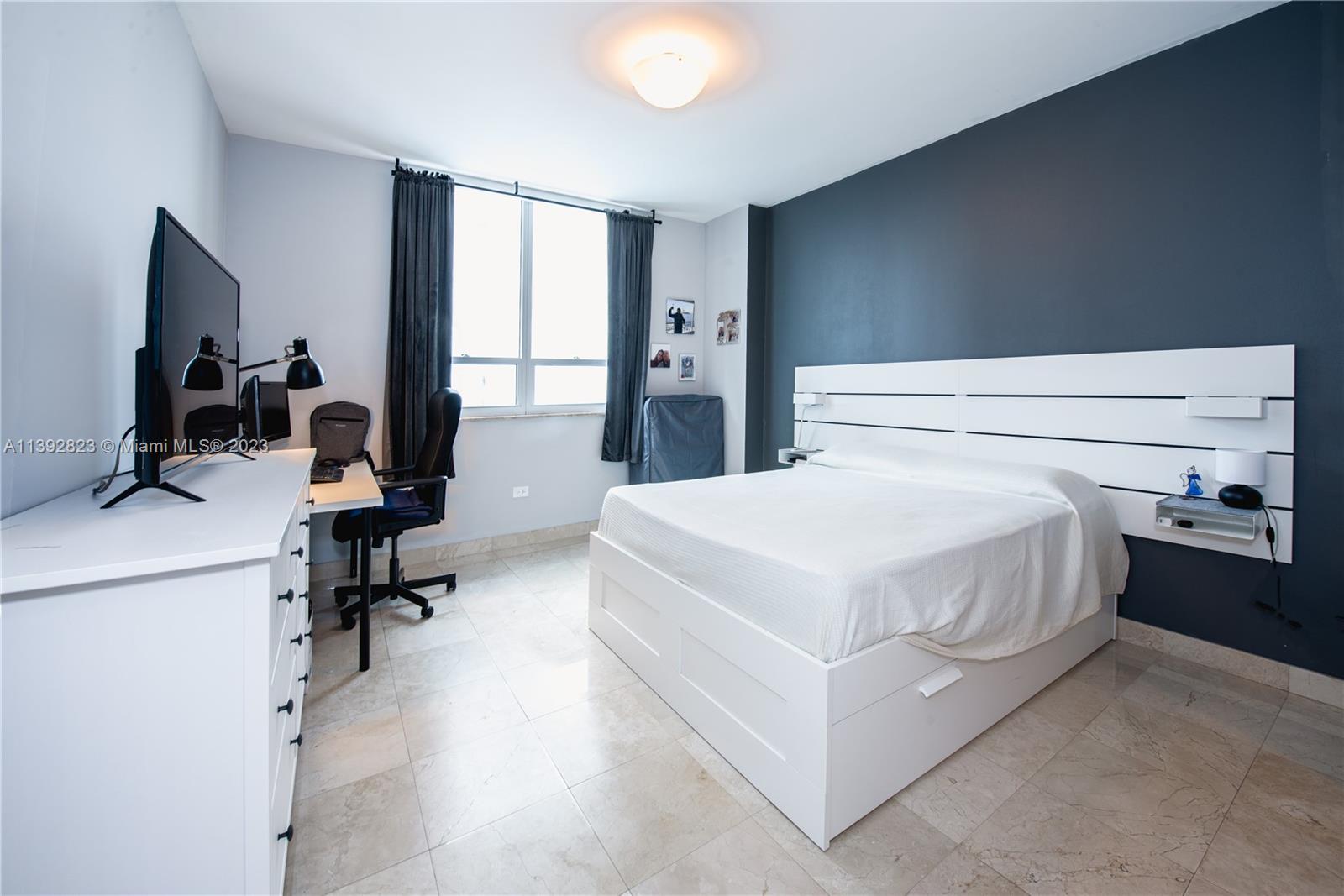 Brickell Miami, FL 33131 - Photo 10 of 50 a bedroom with a bed and a flat tv screen on the dresser