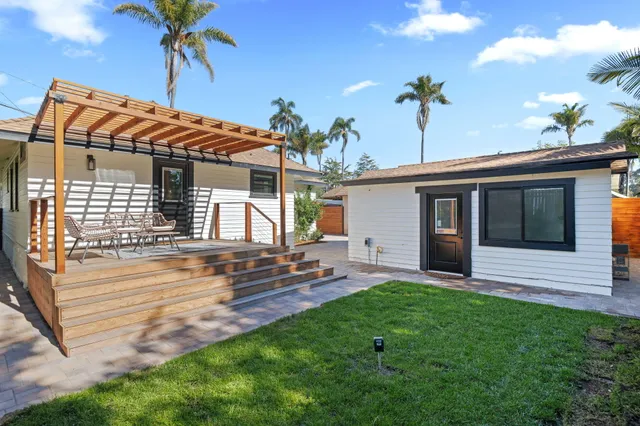 an aerial view of a city with lots of residential buildings and ocean view in back