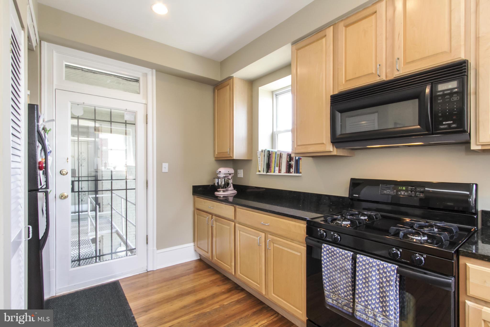 1423 R Street Northwest, Unit 505 Washington, DC 20009 - Photo 11 of 22 a kitchen with stainless steel appliances granite countertop a stove a sink and a microwave