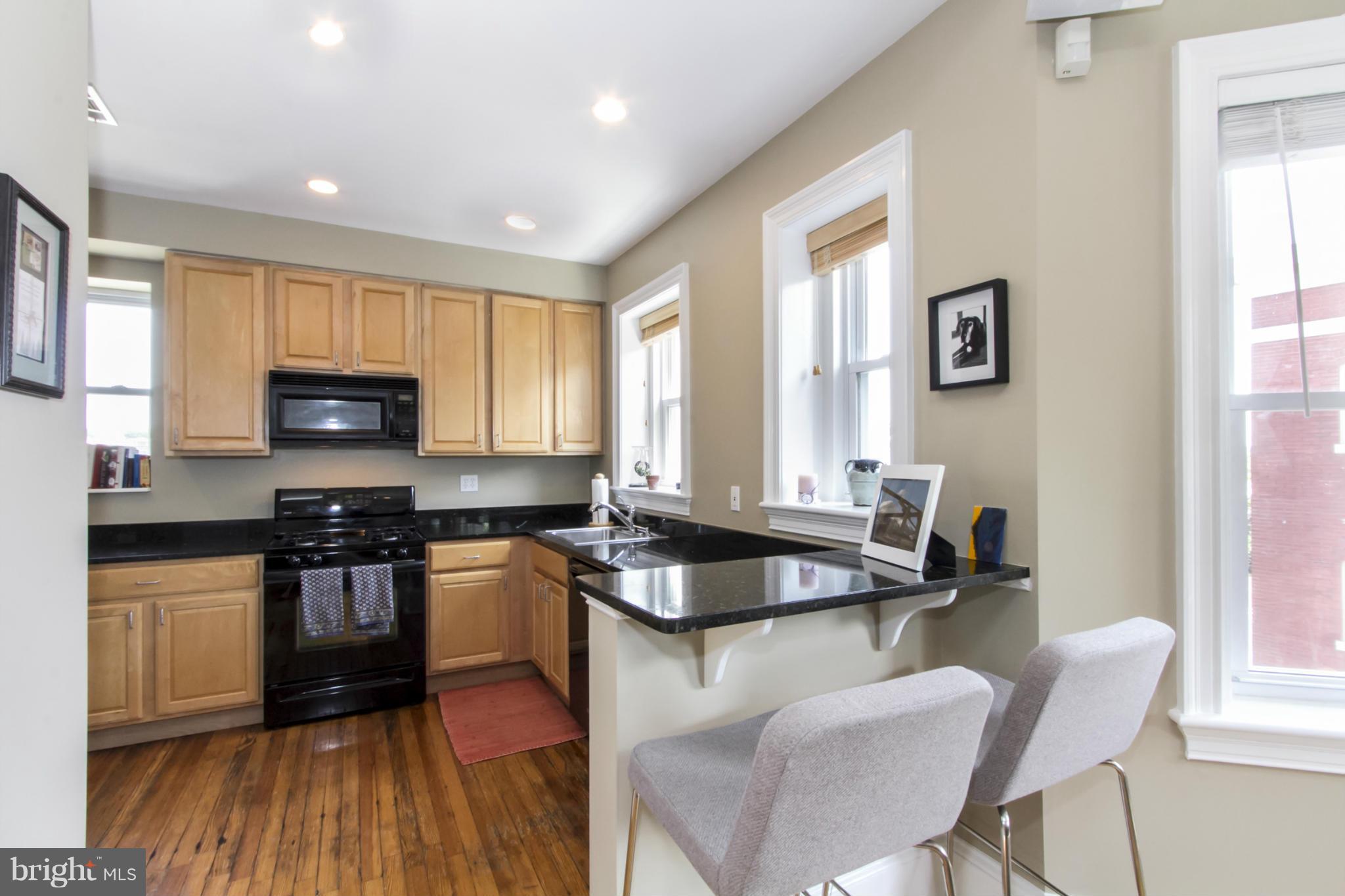 1423 R Street Northwest, Unit 505 Washington, DC 20009 - Photo 9 of 22 a kitchen with granite countertop wooden floors appliances and window