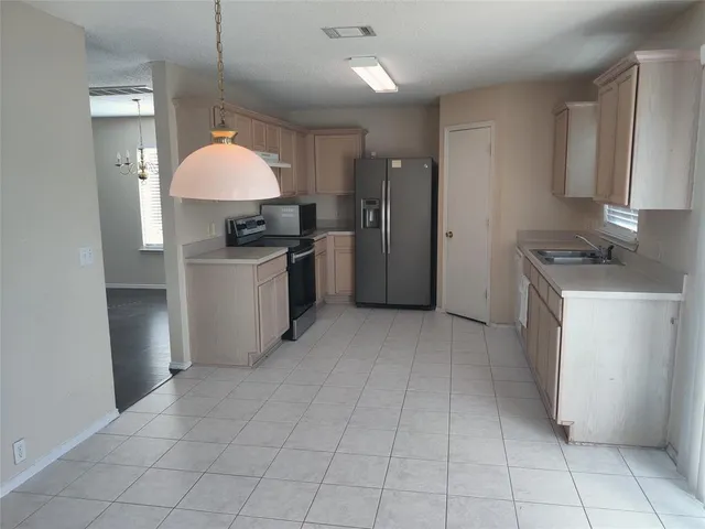 a kitchen with a sink a stove and a refrigerator