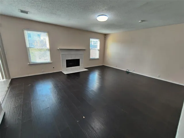 an empty room with wooden floor and fireplace